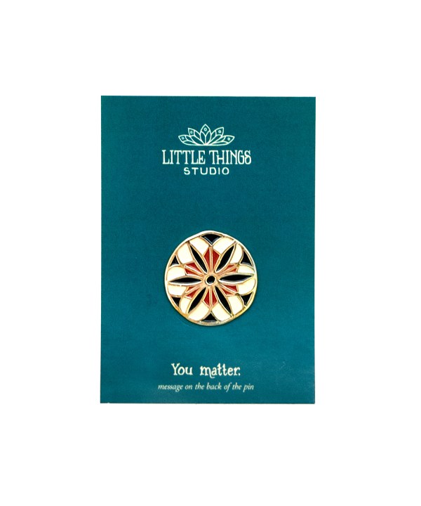 The You Matter enamel pin, shown with its deep teal cardboard backer.