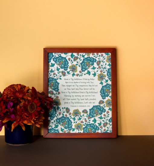 Great Is Thy Faithfulness lyric artwork — a Christian artwork print of the beloved hymn text, hand lettered and printed on a cream background, illustrated with brilliant floral design in shades of teal, blue, and orange, displayed in a dark wood frame with a vase of fresh flowers