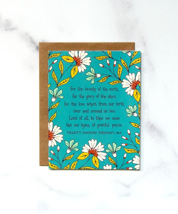 Send words of praise and truth to loved ones with this "For The Beauty" Greeting Card, featuring text of the beloved hymn, framed by a beautiful floral with a striking blue background, shown against a marble background.