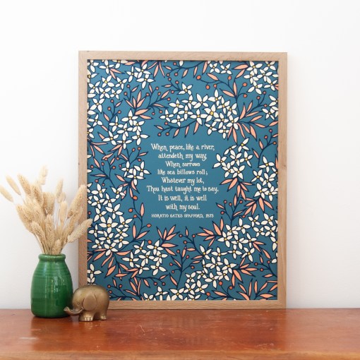 16 x 20 It is Well with My Soul wall art, featuring hand-lettered text on a deep teal background surrounded by illustrated floral in cream and light pink, displayed in a light wood frame accented by a vase of dried grasses and an animal figurine