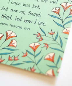 Text and illustration detail of the Amazing Grace greeting card, which features a delicate floral design on a fresh green background.