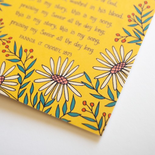 Floral and text detail of the Blessed Assurance greeting card, which features illustration of lively white floral and greens bordering the text of the beloved hymn, shown against a white background.