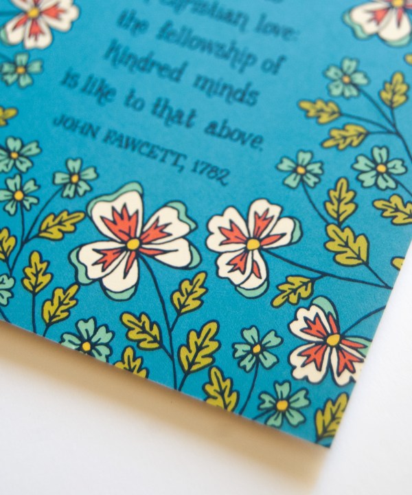 Floral and text detail of The Blest Be the Tie greeting card, which features delicate floral illustration with a bright blue background, shown here against a white backdrop.