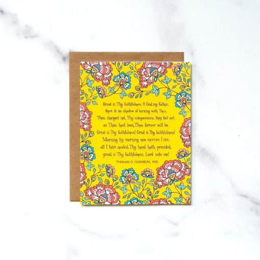 The Great is Thy Faithfulness greeting card features vibrantly colored floral design against a striking yellow background; displayed against a white marble background.