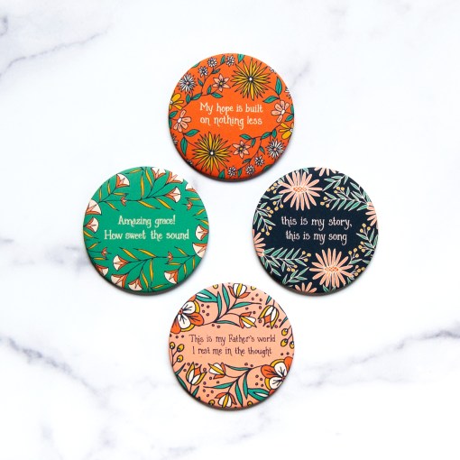 Each hymn magnet in this set of 4 includes a hand-lettered line from a much loved hymn framed by lively florals over a gorgeous background. Shown against a marble backdrop.