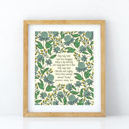 Holy Holy Holy art print — biblical wall art featuring hand lettered text surrounded by floral illustrations in shades of blue, yellow, and green, displayed in a light wood frame
