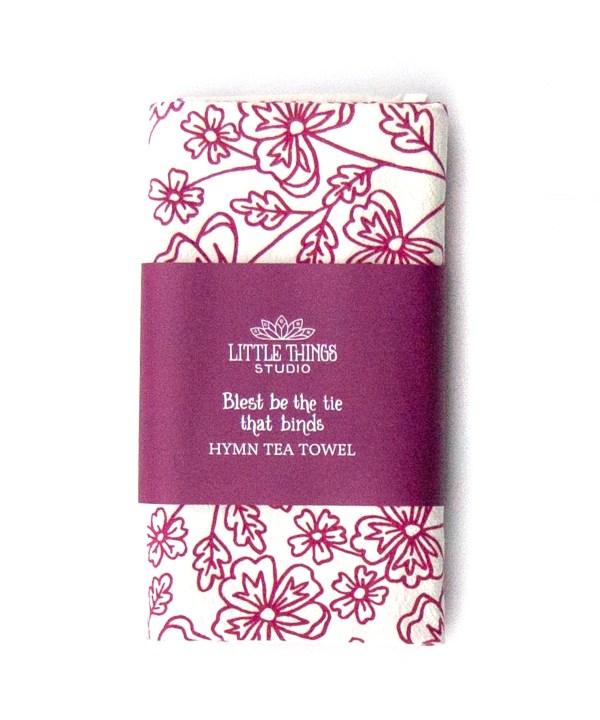 Blest Be the Tie hymn tea towel, printed on a cotton flour sack in plum purple, displayed folded with a paper belly band for gift giving