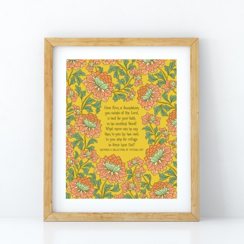How Firm a Foundation art print — hand-lettered hymn text on a mustard background surrounded by a floral design using light red, light blue and green, pictured in a light wood frame