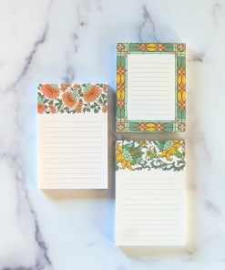 three small notepads with floral illustration and lines for writing