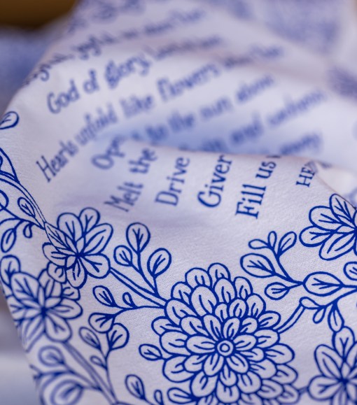 Text detail of Joyful, Joyful We Adore Thee hymn tea towel, which features the beloved hymn is printed in blackberry blue.