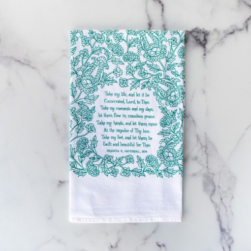 The Take My Life and Let It Be hymn tea towel featuring the beloved hymn is printed in an aqua green, shown folded on a marble background.