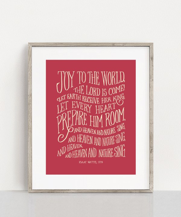 oy to the World Christmas hymn art print features hand-lettered text against a festive cranberry background, displayed in a light gray wood frame