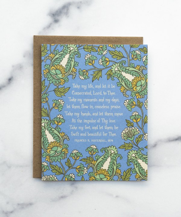 The Take My Life and Let It Be hymn greeting card, framed by saffron and moonstone floral against a stormy blue background, shown with a kraft paper envelope against a marble background.