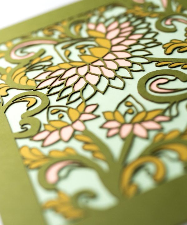 Detail image of the Layered Floral Papercut “Margot” (Spearmint) which is made using cardstock in hues of Jellybean green, salmon, mustard, spearmint.