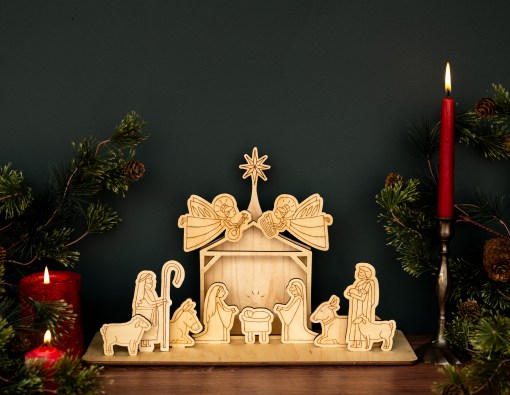 This wooden nativity set from Little Things Studio is an heirloom that will be cherished for generations to come. Joseph and Mary gaze upon baby Jesus while the angels announce His glorious arrival. Shepherds and animals joyfully survey the holy scene as the star shines brightly above. Shone here assembled and styled with a lit taper candle, pillar candles, and greenery.